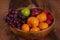 Spicy fruit salad on banana leaf in black dish on Rattan background.