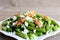 Spicy green bean salad recipe. Baked green beans salad with cottage cheese, crunchy walnuts, garlic and spices on a plate