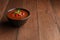 Spicy Homemade Gazpacho Soup with basil on wood table.