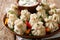 Spicy homemade khinkali with sour cream, pepper and herbs close-up on a plate. horizontal