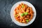Spicy penne bolognese with parmesan and basil
