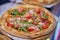 Spicy Pizza with Salami, Mozzarella, tomatoes, arugula and Tomato Sauce. Italian pizza.