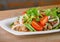 Spicy pork salad, Thai cusine on wooden background