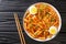 Spicy Rabokki is a variation of tteokbokki  with ramen noodles served with boiled eggs closeup in the bowl. horizontal top view