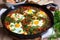 Spicy Shakshuka in a Cast Iron Skillet with Fresh Herbs and Crusty Bread