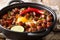 Spicy and sizzling pork sisig is a favorite for Filipinos close-up in a pan. horizontal