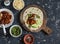 Spicy stewed beans, avocado, green chile sauce, cheese tortilla on a cutting board