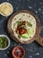 Spicy stewed beans, avocado, green chile sauce, cheese tortilla on a cutting board