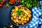 Spicy summer salad with sweet corn, red beans, avocado, jalapeno, red tomatoes, onion and fresh cilantro. Blue table background,
