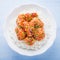 Spicy sweet and sour chicken with sesame and rice on blue wooden background top view