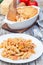 Spicy tomato jalapeno mac and cheese with mini penne pasta, on a plate, vertical