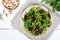 Spicy vegan salad of beets, arugula, pistachio nuts on a plate on a white background.