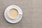 Spicy warming tea with milk in white porcelain cup on textile background