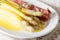 Spicy white asparagus with Dutch sauce and prosciutto ham close-up. Horizontal