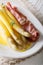 Spicy white asparagus with Dutch sauce and prosciutto ham close-up. vertical