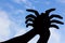 Spider shape hand silhouette in blue sky and cloud.