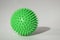 Spiky massage ball on the white background with hard lights and isometric shadow