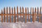 Spiky wooden fence in the snow, winter mountain landscape in the background