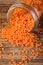 Spilled red lentils from glass jar