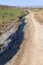 Spilled streams of liquid crude oil flow down drainage ditch into public body of water. Environmental disaster Oil pollution of