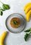 Spinach and banana pancakes and green leaves and bright fruits on a gray plate on a gray background.