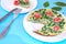 Spinach frittata ,italian omelet with cherry tomatoes in a white plate on a blue background. Healthy food conception