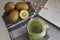 Spinach and kiwi smoothie with laptop and two strip straws on gray background with kiwis.Healthy work space ,time break, freelance