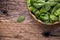 Spinach leaves.Fresh spinach leaves in retro bowl on oak wood board.