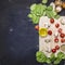 Spinach leaves and sliced mushrooms, laid out on a cutting board with herbs and cherry tomatoes on wooden rustic background top vi