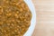 Spinach and lentils on a plate atop a wood table