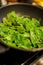 Spinach with olive oil being cooked in a pan