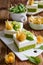 Spinach sponge cake topped with curd mixed with whipped cream, decorated with golden berries and kiwi slices