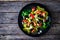 Spinach tagliatelle with parmesan, cherry tomatoes, black olives and basil on wooden table, top view