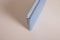 Spine of book, photobook, notebook or photoalbum in light blue leather cover on white table background. Top view, copy space
