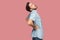 Spine, kidney back pain. Profile side view portrait of sad sick bearded young man in blue casual style shirt standing and holding