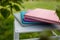 Spines of books, albums, notebooks or photobooks with grey, turquoise, purple and pink leather covers lying on white wooden box