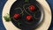 Spinning flat plate with the inscription spaghetti pasta on a black round and wooden board background.