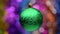 Spinning New Year's ball green color on blurry bokeh background of glowing tinsel, holiday lights