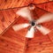 Spinning white ceiling fan in gazebo.