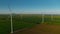 Spinning wind towers generating energy in fields. Drone view of wind turbines.