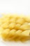 Spiral fusilli dired pasta macro over white