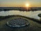 Spiral labyrinth made of stones on sunset lake