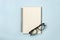 Spiral Notebook or Spring Notebook and Eyeglasses on Pastel Minimalist Background