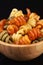 Spiral pasta trottole tricolore in wooden bowl