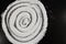 Spiral pattern of white flour on black countertop background