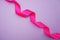Spiral Pink ribbon with space copy on purple background