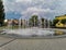 Spiral splashing fountain at city center in cloudy day