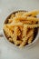 Spiral tortiglioni pasta in marble plate with two handles on light background. homemade pasta made from durum wheat. raw dish.