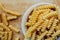Spiral tortiglioni pasta in plate in bright kitchen. homemade pasta made from durum wheat. the process of cooking flour dishes.