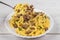 Spirals pasta Bolognese. Tagliatelle with minced meat on a white plate on a wooden background